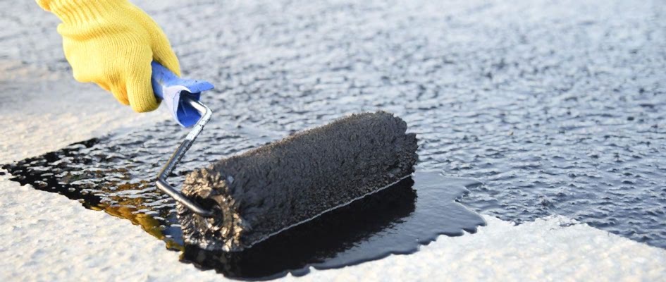 Teras su yalıtımı uygulaması yapılır sarı eldivenli kişi tarafından.